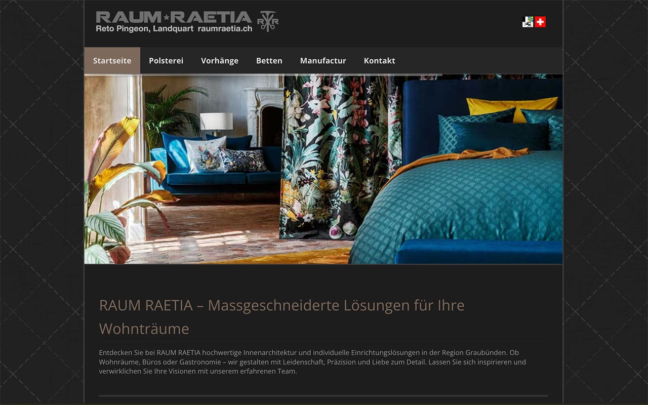 Schlafzimmer mit blauem Polsterbett, gemusterten Vorhängen und Sofa